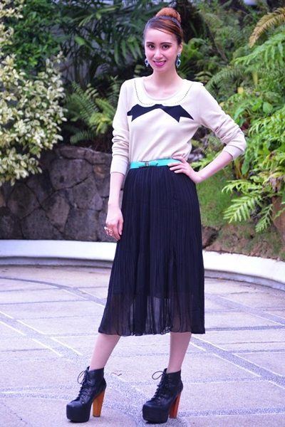 Embrace alterna-chic style by pairing Yishion’s semi-sheer black pleated skirt with a bow-print lightweight top.